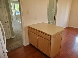 Kitchen featuring light countertops, light brown cabinetry, refrigerator, dark wood-type flooring, and a peninsula