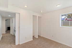3rd bedroom featuring light colored carpet, recessed lighting, and baseboards