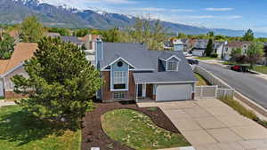 Traditional-style house with vinyl fence, concrete driveway, brick siding, RV parking and a residential view