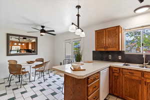 Kitchen featuring white appliances, a sink, a peninsula, and healthy amount of natural light