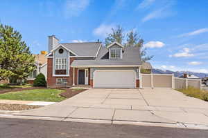 View of front of home with concrete driveway, brick siding, an attached garage, roof with shingles, and a chimney