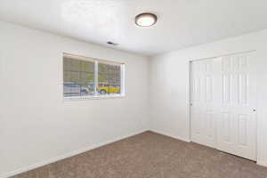 2nd bedroom featuring carpet, a closet, baseboards, and a textured ceiling