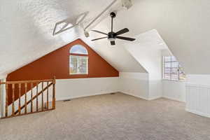 Additional living space, bonus room or bedroom with a textured ceiling, ceiling fan, plenty of natural light, carpet floors, and vaulted ceiling