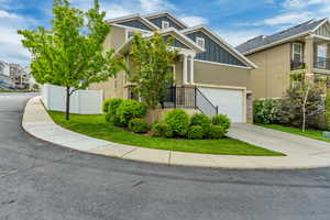 View of front of house featuring board and batten siding, fence, an attached garage, stucco siding, and concrete driveway