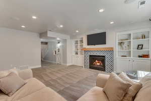 Living room with baseboards, stairway, recessed lighting, and light colored carpet