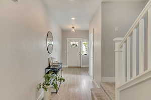 Entryway featuring baseboards, stairway, light wood-style flooring, and recessed lighting