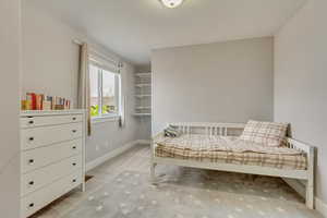 Bedroom featuring light carpet and baseboards