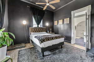 Bedroom with ornamental molding, ceiling fan, visible vents, wood finished floors, and arched walkways