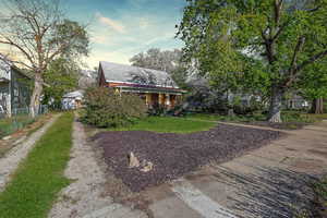 View of front of house featuring fence and a front lawn