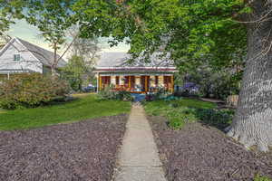 Bungalow-style home featuring covered porch and a front lawn