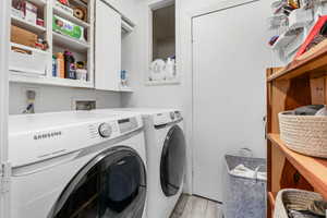 Laundry room featuring washer and clothes dryer, laundry area, and light wood-style floors