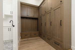 Mudroom featuring light wood-style flooring and a sink