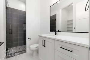 Full bathroom with a stall shower, toilet, and vanity