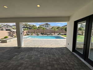 View of pool with a patio, a fenced backyard, and an in-ground hot tub