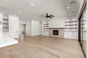 Unfurnished living room featuring a barn door, a ceiling fan, light wood finished floors, recessed lighting, and built in features