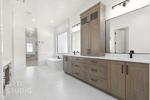 Full bath with a soaking tub, double vanity, marble finish flooring, and recessed lighting