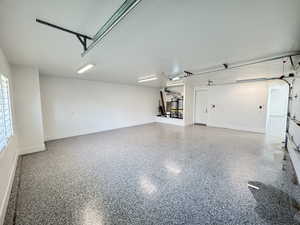 Garage featuring baseboards and a garage door opener