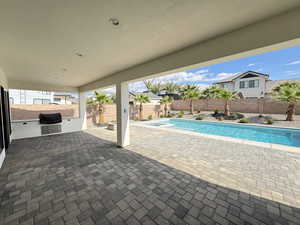 View of pool with a patio area, exterior kitchen, and a fenced backyard