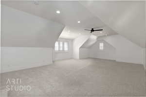 Additional living space with vaulted ceiling, recessed lighting, plenty of natural light, light carpet, and baseboards