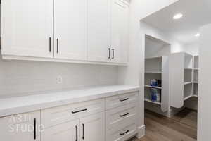 Kitchen featuring white cabinets, light wood-style flooring, light stone counters, and recessed lighting
