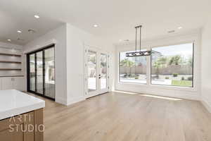 Unfurnished dining area with french doors, baseboards, light wood-style floors, recessed lighting, and built in features