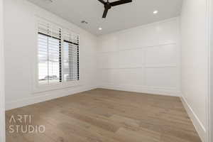 Empty room with a ceiling fan, light wood finished floors, recessed lighting, baseboards, and a decorative wall