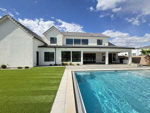 Back of house with a patio, stucco siding, a yard, and an outdoor pool