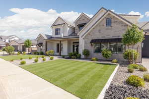 View of front of home featuring board and batten siding, a front lawn, a standing seam roof, and metal roof