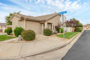 View of property exterior with a tile roof, stucco siding, and fence