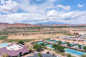 Drone / aerial view of a mountain backdrop and a local golf course