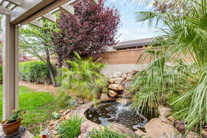 View of yard featuring a garden pond and fence