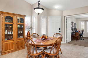 Dining space with light tile patterned floors, an office area, light carpet, and baseboards
