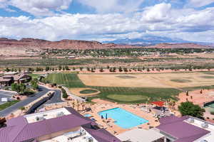 Drone / aerial view of a mountainous background, a pool, and a local golf course