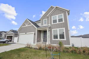 View of front of home with board and batten siding, driveway, and a garage