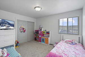 Bedroom with a textured ceiling, a closet, and carpet