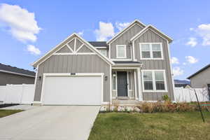 Craftsman-style home featuring board and batten siding, driveway, and a garage