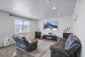 Living room with wood finished floors, recessed lighting, a textured ceiling, and baseboards