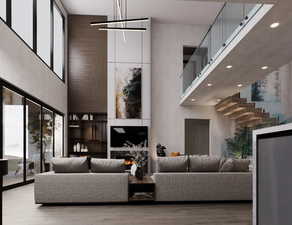 Living area featuring a high ceiling, recessed lighting, wood finished floors, and a chandelier