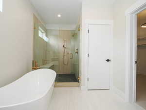 Full bath featuring a shower stall, a freestanding tub, and recessed lighting
