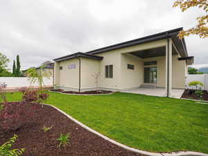 Back of house with a patio area and stucco siding