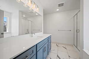 Bathroom with marble look tile flooring, a stall shower, vanity, baseboards, and recessed lighting