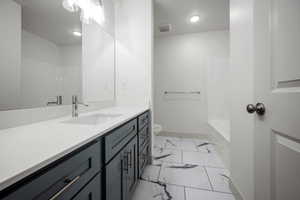Full bathroom featuring marble look tile flooring, vanity, toilet, recessed lighting, and baseboards