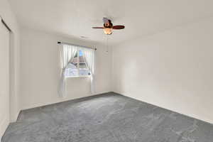 2nd bedroom with carpet, fan and closet