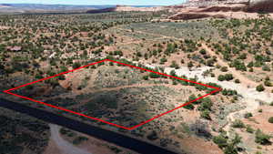 Aerial view of sparsely populated area with property parcel outlined and a desert landscape