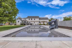 View of swimming pool featuring a water slide, a gazebo, and a wooden deck