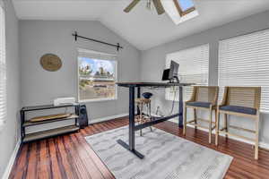Office/Sunroom featuring ceiling fan, a skylight, vaulted ceiling, wood finished floors, and baseboards