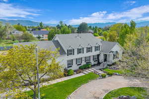 View of front of house with a front lawn, a mountain view, with ample parking