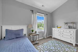 (4) Bedroom with lofted ceiling, carpet floors, and baseboards