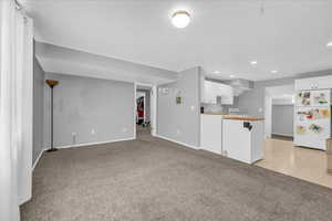 ADU Unfurnished living room with light colored carpet, baseboards, and recessed lighting