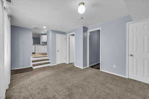 Unfurnished living room featuring carpet floors and baseboards